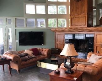 Beautiful family room/game room furnishings.  Tufted leather sofas with rolled arms (2), end tables, lamps and large coffee table.  Oh yes,!  That IS a moose head on the wall and it is for sale.  