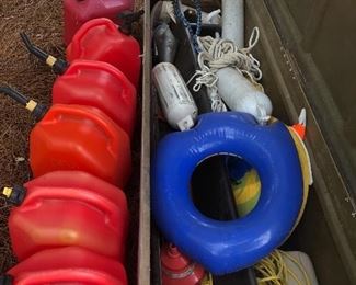 Six portable gas tanks, boat bumpers, rope, and other boating equipment.  