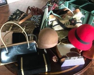 A table full of designer handbags and hats.  