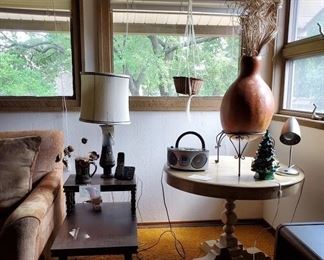 African gourd, round top table, lamps, hanging baskets and plants