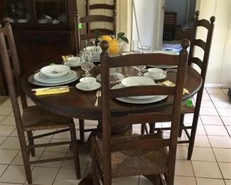 Round oak table with 6 high back chairs, cane bottoms.