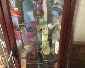 Small glass cabinet with little shoes.