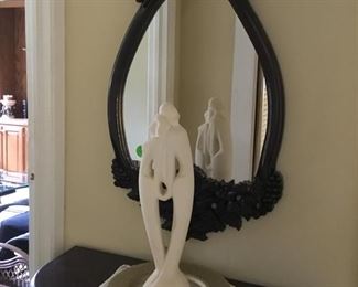 SmLl table with matching mirror and beautiful statue.
