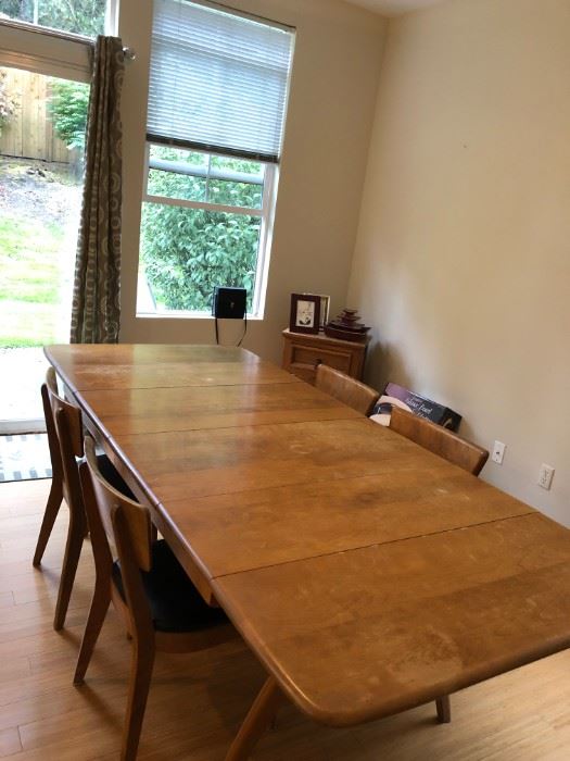 Mid-century modern dining table with 5 leather chairs.
