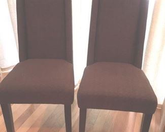 Photo of two of actually four matching high back dining chairs with chocolate brown fabric; detail of pattern in next photo