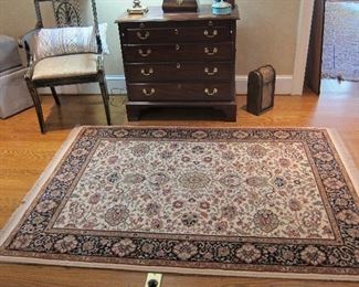 GREAT RUG WITH A HENKEL HARRIS BATCHLORS CHEST IN THE BACK GROUND.