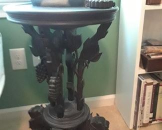 Intricately carved table with clusters of grapes. Duck decoy.