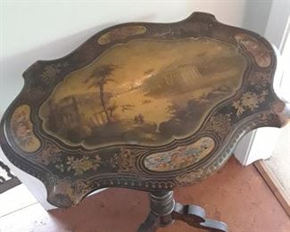 Ebonized tilt top table with classical scenes
