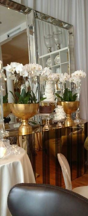 Multi-sized and sectional bars in a range of finishes including gold, mirror and smoked acrylic. 7.5' x 4.5' silver, beveled floor mirrors. Opulent, gold champagne and punch bowls. Rococo, multi-tiered pedestal cake plates. 