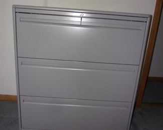 Gray steel filing cabinet with key.