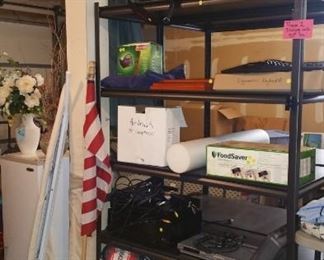 Foodsaver, queen air mattress, pump, suitcases, briefcase, chess set w/glass animal pieces, blankets, flag, ironing board, more. Two heavy duty steel shelving units: $50.00 each.