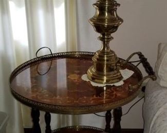 Round side table with handle and wheels, brass lamp
