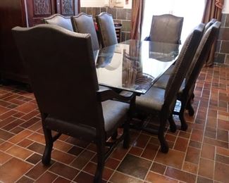 Rectangular dining table with bronze stag base and glass top with eight custom chocolate textured faux leather chairs