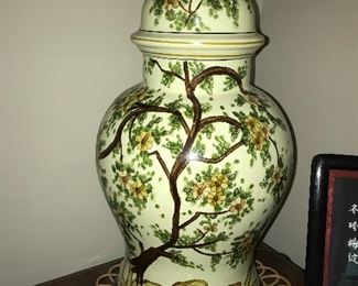 Two-drawer file cabinet with the look of nice furniture, Asian-themed lamp, wall decor.