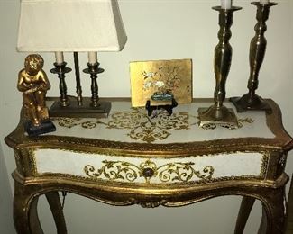 Vintage Italian gold leaf desk with one drawer, candlesticks, lamp and other decor.