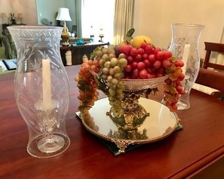 Tabletop decor--crystal candlesticks with prisms and hurricane globes, tray mirror, fruit in bowl.