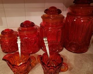 Red depression glass canisters and assorted additional pieces