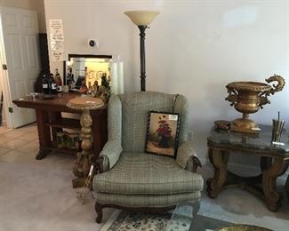 Trestle table, bar mirror, oversized upholstered chair, marble-topped accent table, dragon urn. 