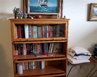 Oil painting of ship. Vintage books in lawyers style bookcase