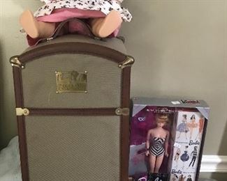 American Girl and trunk of clothes next to new Barbies