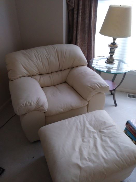 White leather overstuffed chair with matching ottoman