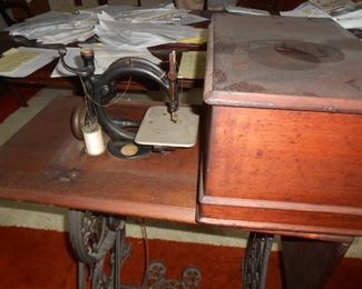 Victorian sewing machine with cover and treadle base.  (Needs a new band)