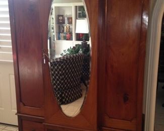 Antique armoire with oval mirror