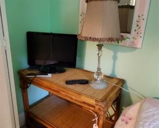 bamboo table and lamp, small flatscreen tv with book and remote