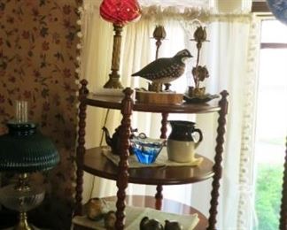3 shelf round side table, 2 gal crock 2/ turkey dropping, cranberry glass lamp, misc. collectibles