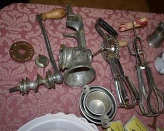 Antique and Collectible Kitchenware pictured here is a Meat Grinder, Measuring Cups, and Egg Beaters!