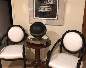 Ivory upholstered black lacquer arm chairs, mahogany side table, mirrored pedestal and ceramic artwork, along with framed signed lithograph