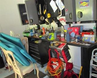 Garage packed with tools, car, garden and home maintenance products, compressor, fishing gear