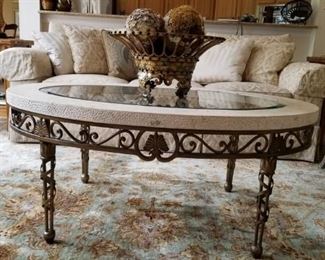 Oval coffee table with stone and glass top on iron base