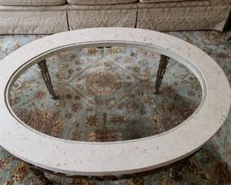 Oval coffee table with stone and glass top on iron base