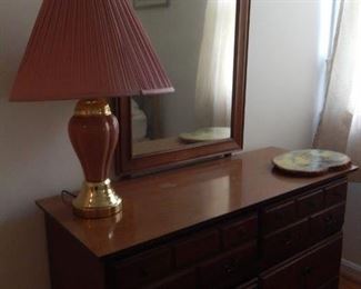Bedroom dresser and mirror. Large pink lamp.
