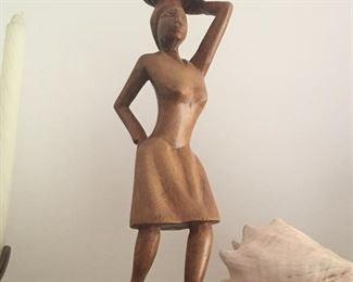 Carved wooden figure: woman carrying a basket.