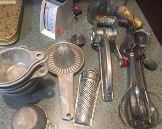 Vintage kitchenware: hand beater, Mouli grater, aluminum measuring cups, aluminum reamer, PAMCO chopper...