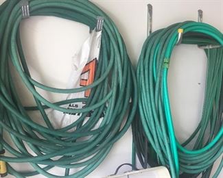 Lawn hoses, along with an assortment of hand tools and lawn/garden gear