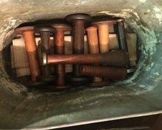 Old wooden spools in copper bucket. 