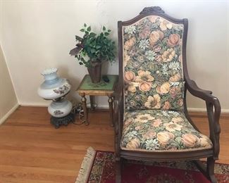 Antique carved walnut winged rocking chair with brocaded fabric
