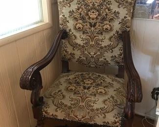 Antique carved walnut winged chair with brocaded fabric