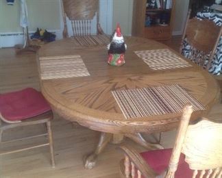 Oak dining room set with six chairs. Measures 46" round plus 24" leaf as shown.   4 side plus two arm chairs.  Presale $250