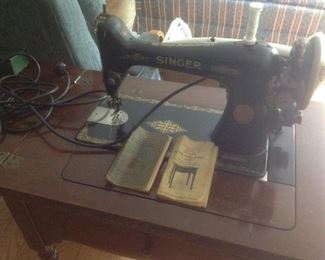 Antique singer sewing machine in the cabinet.  Has original instruction book.