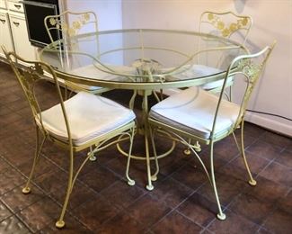 Painted wrought iron glass top table with four chairs