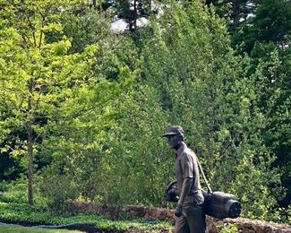 Absolutely amazing larger than life bronze outdoor sculpture of golfer walking with bag.