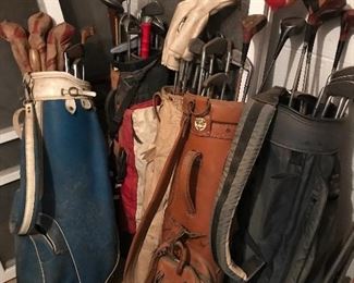 Several bags of vintage golf clubs.
