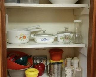 3 large plastic pitchers, large covered plastic bowl-SOLD, 2 Corning ware saucepans in "Meadow", "Cornflower" baker with glass lid & plastic cover, "Spice of Life" baker with lid-SOLD, Bromwell metal sifter, vintage Tupperware, some food items 