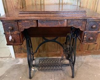 Pedal sewing machine. Top opens and machine pops up on a pulley system.