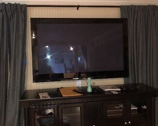 Several items are for sale in this photo.  Beautiful panel drapes and curtain rod.  Have many various ones throughout the home.  This Espresso colored Entertainment Console with glass doors as well as the 55" TV - all sold separately.  