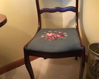 Antique chair with needlepoint seat cover.